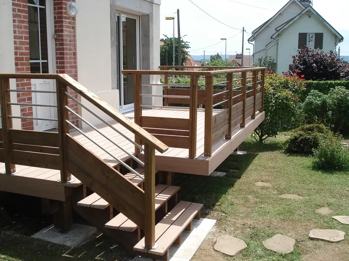 Erhöhte Holzterrasse mit Geländer, Edelstahlhandlauf und Außentreppe an einem Wohnhaus