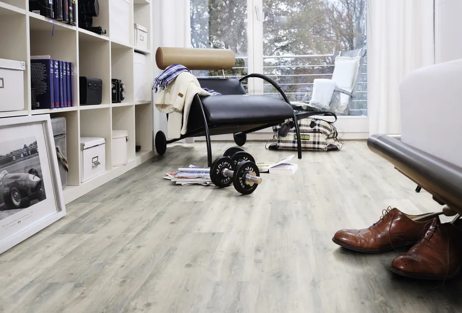 Arbeitszimmer mit hellgrauem Designboden in Holzoptik und Regalwand