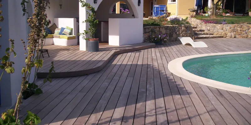 Holzterrasse mit geschwungener Kante rund um einen Swimmingpool